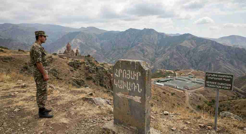 An Armenian soldier standing near mountains, representing military service in Armenia.