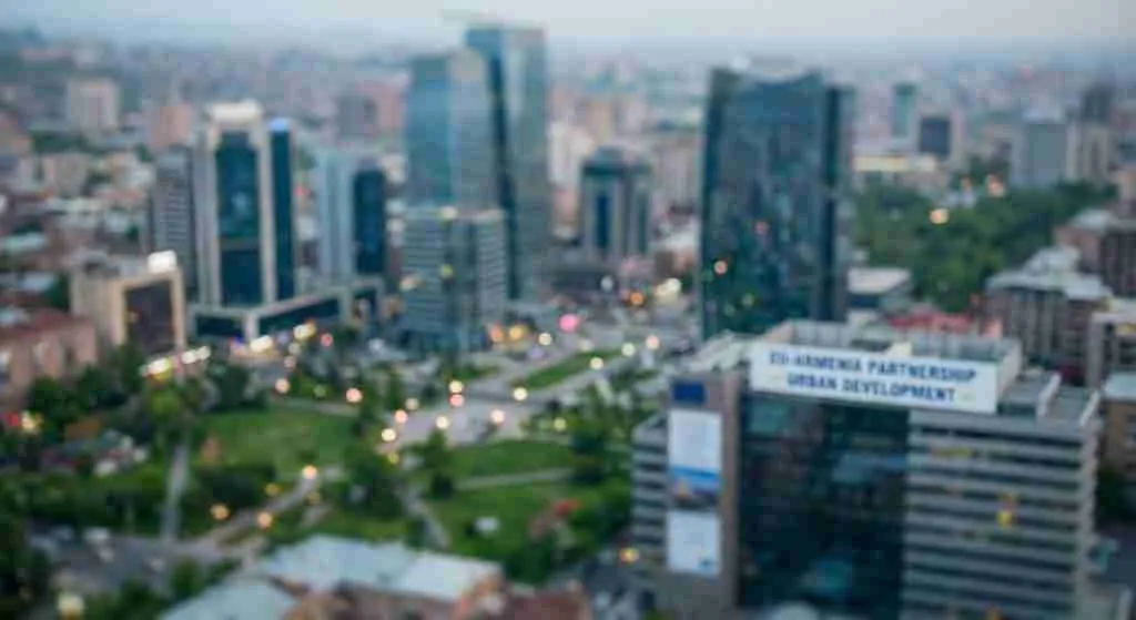 Aerial view of a city skyline featuring modern buildings and green spaces.