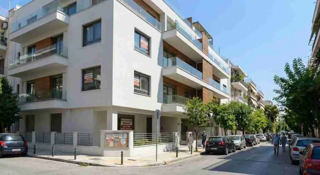 ग्रीस के एथेंस शहर में आधुनिक आवासीय इमारतों को दर्शाने वाला एक सड़क का दृश्य।