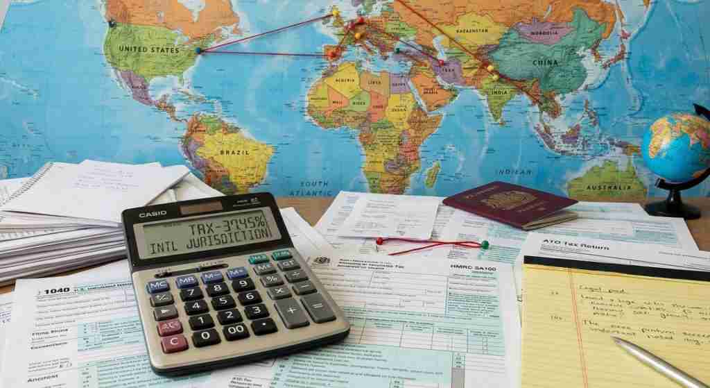 Calculator and financial documents on a desk with a world map backdrop.