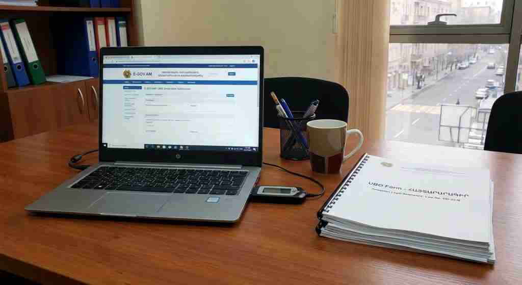 A modern office desk with a laptop, legal documents, and an electronic signature device.
